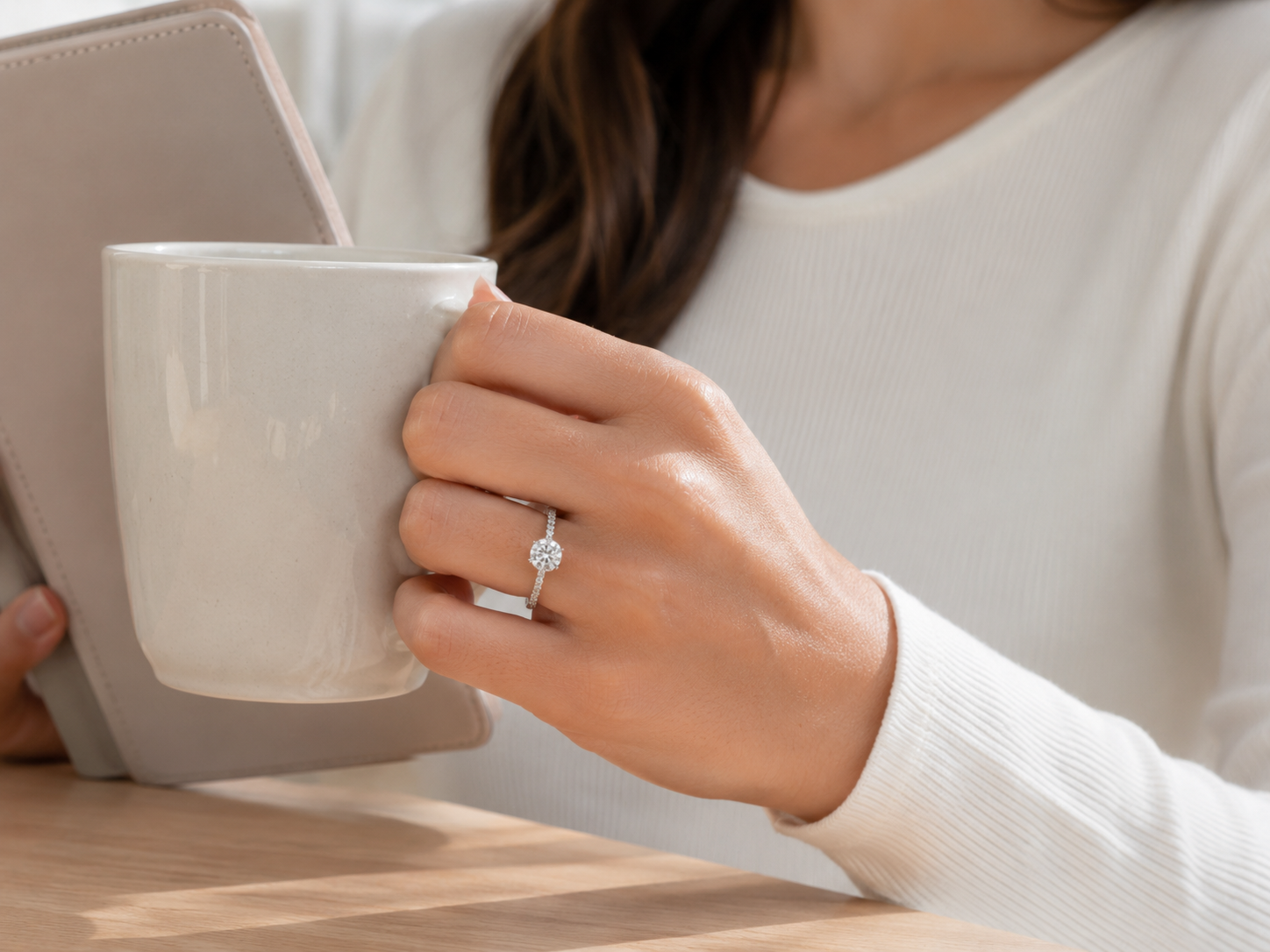 Woman wearing an everyday moissanite ring while holding a coffee cup