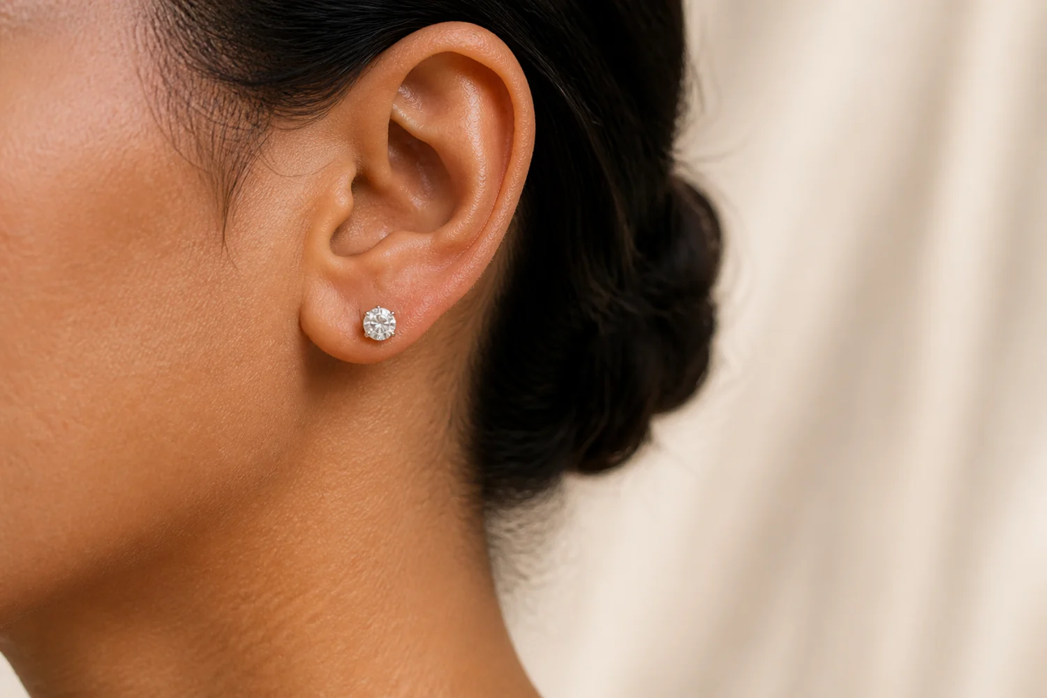 Medium-size round moissanite stud earring worn on an adult ear
