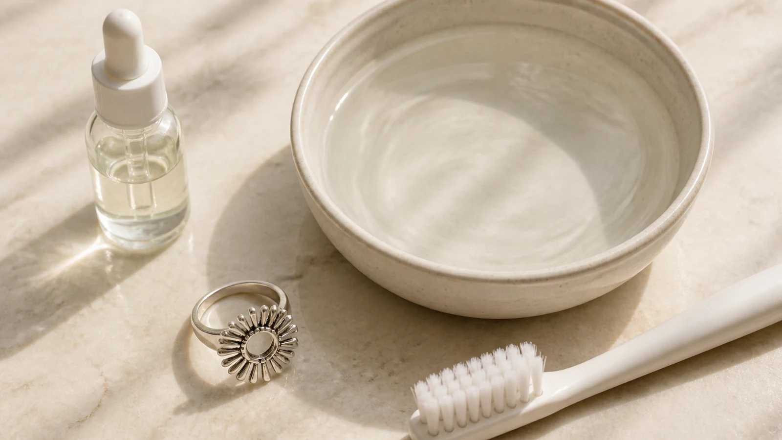 Warm water, a soft brush, and an unbranded mild-soap bottle beside a generic sunburst ring