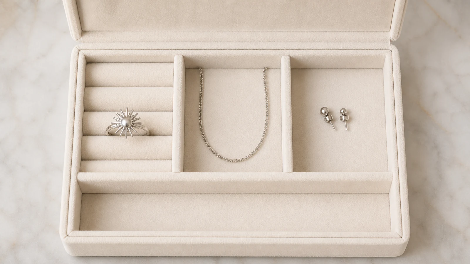 Generic sunburst ring stored alone in a padded slot with a chain and studs in separate compartments