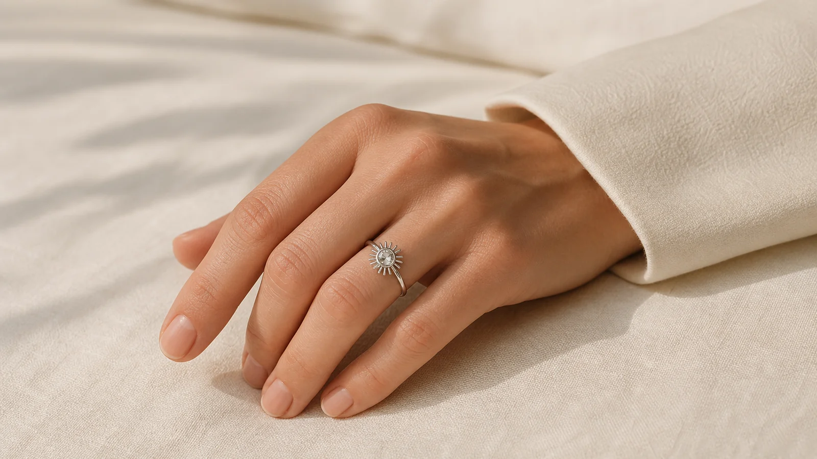 Woman wearing a generic silver-tone sunshine ring with a neutral ivory outfit