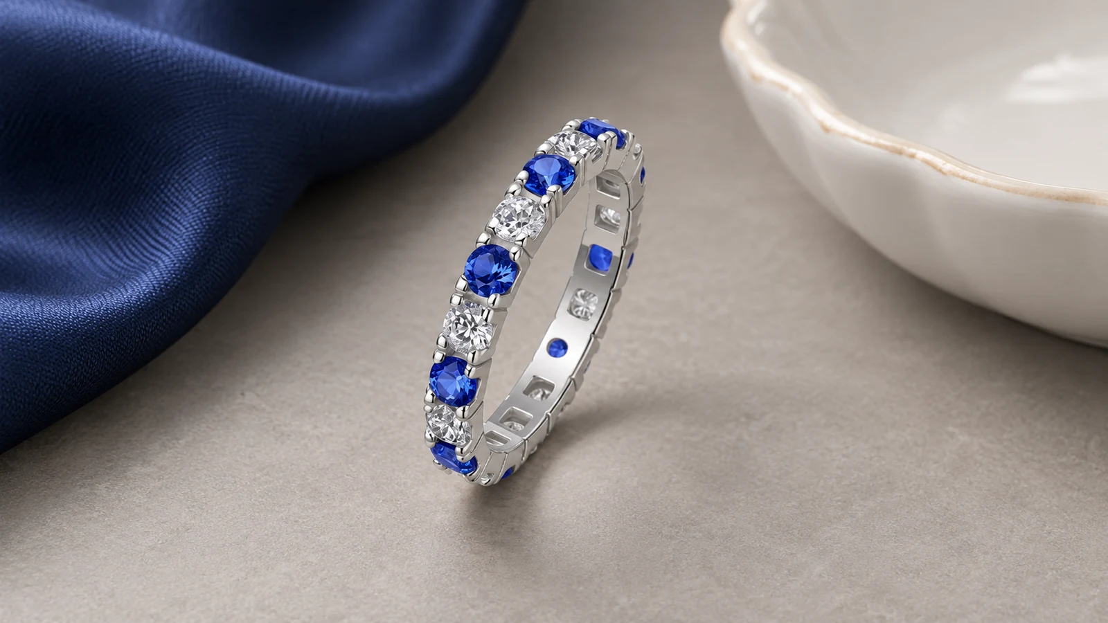 Blue and white moissanite eternity band styled with navy silk