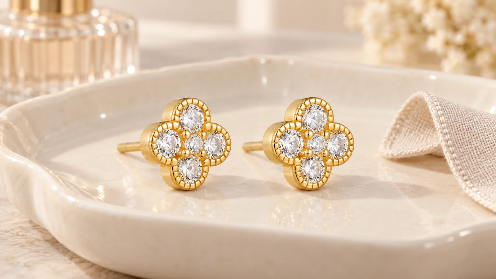 Gold-tone five-stone flower stud earrings on an ivory tray