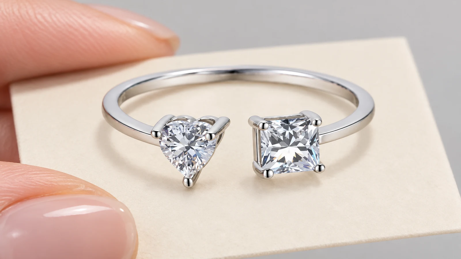 Open bypass ring showing a heart-cut stone beside a princess-cut stone