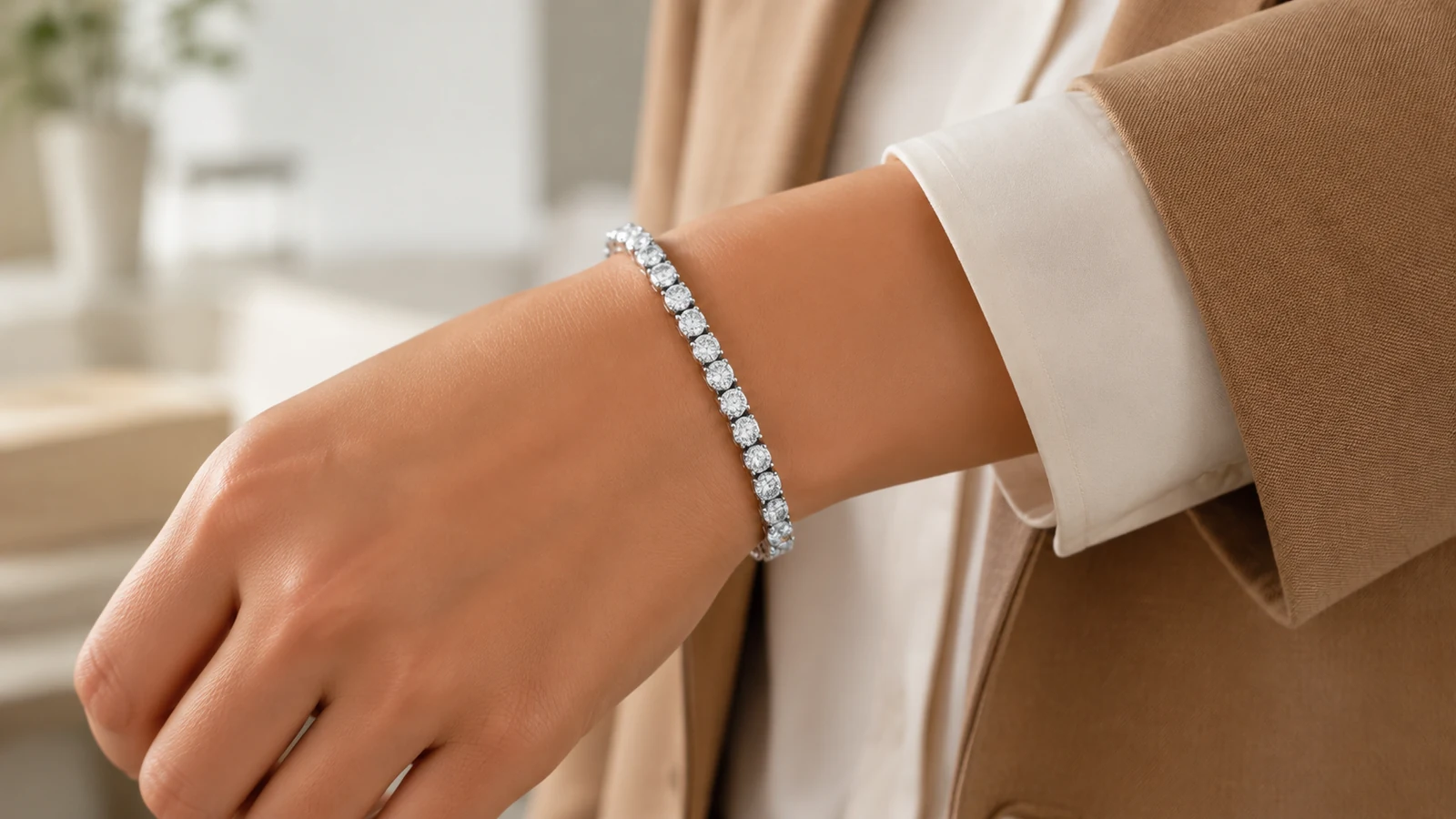 Elite round moissanite tennis bracelet styled with an ivory blouse and camel blazer